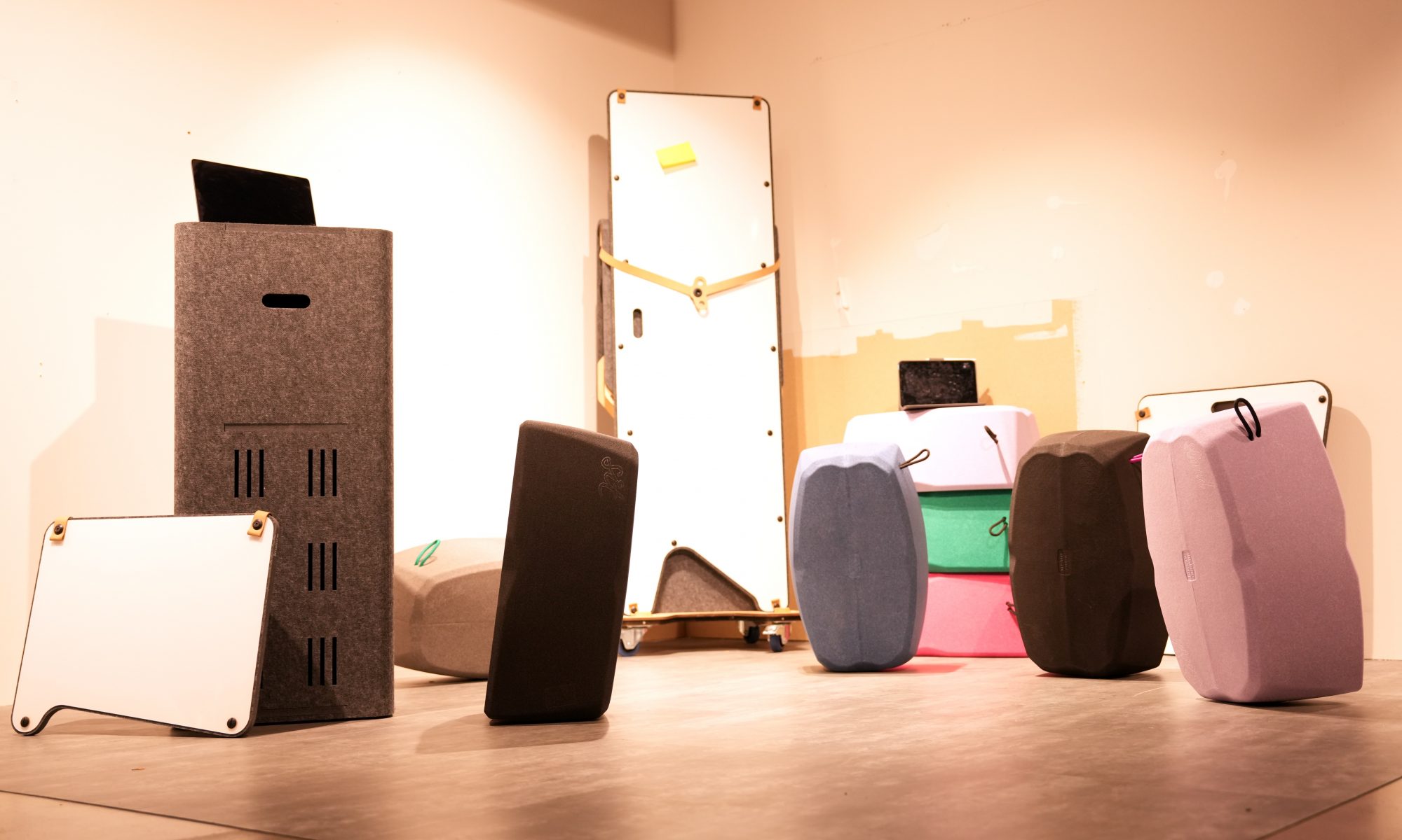 Eine Auswahl an ergonomischen Sitzkissen in verschiedenen Farben und Ausrichtungen in einem modernen Atelierraum.