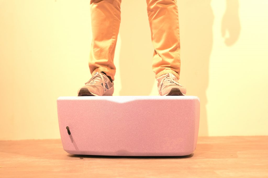 Nahaufnahme eines fliederfarbenen Sitzkissens, auf dem eine Person steht, um die Formstabilität des Materials zu zeigen.