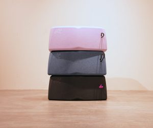 Nahaufnahme eines blauen, grob texturierten Materials mit dem eingeprägten Wort „Stand“ in einer geschwungenen Schreibschrift. Eine schwarz-weiß gemusterte Kordel ist am linken Rand befestigt.